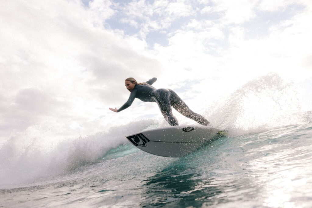 Surfista mujer tomando una ola.